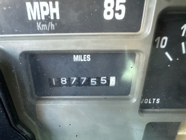 Vehicle odometer display showing MILES with reading 1877556, adjacent gauges including MPH 85 and a partial VOLTS label.