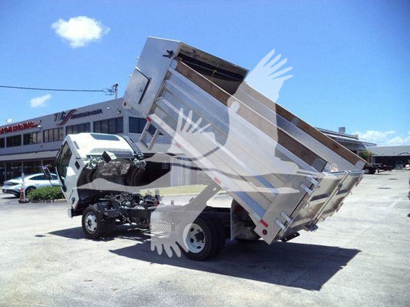Isuzu NQR dump truck with rear tilt bed raised in a dealership lot.