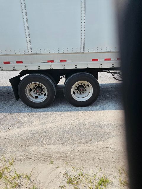 Trailer wheels and a portion of the side wall with red-and-white reflective markings on a Vanguard VXP trailer.