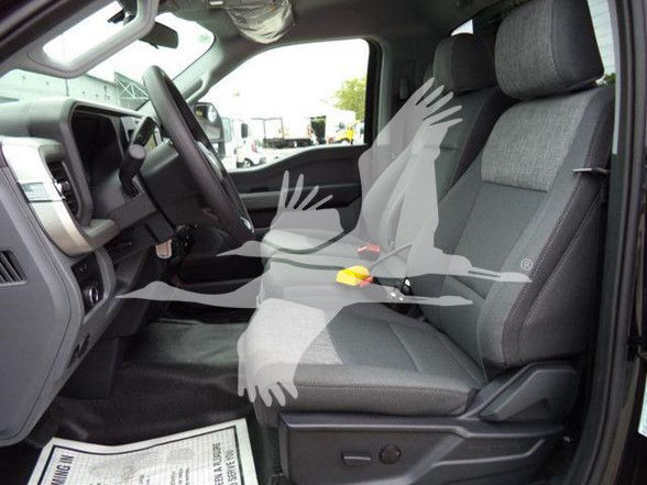 Interior of a Ford F-450 front seats and dashboard view with gray cloth seats and steering wheel visible.