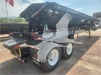Dump trailer with raised bed and dual rear wheels showing stock number 392503 in a dealership lot.