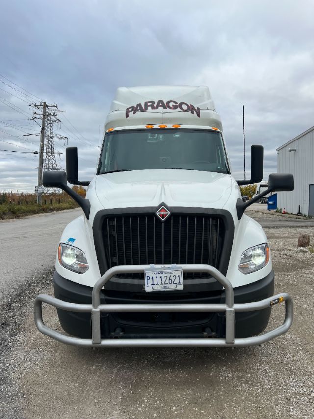 Front view of a white 2019 International LT625 conventional sleeper tractor with Paragon logo on sleeper, large grille, bumper guard, andIllinois plate P1112621.