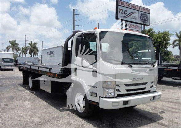Isuzu NRR tow truck chassis with flatbed, front view showing cab, white color, KD mirrors, TL sign in background.