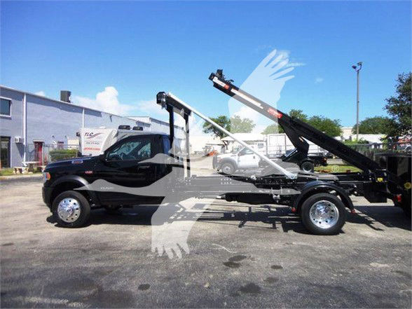 Ram 5500 HD refuse truck with long wheelbase and hydraulic lift, side view, black cab, chrome wheels, blue sky.