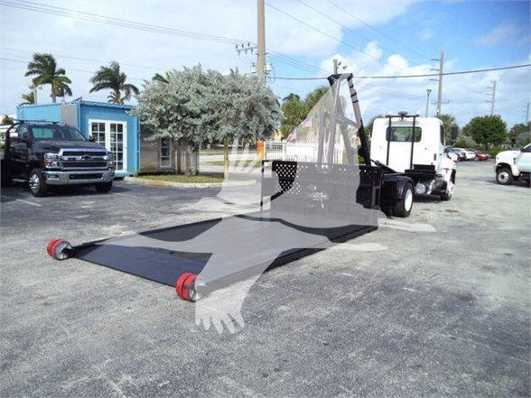 2017 Hino 258LP hooklift truck with a folded flatbed in the foreground and front cab visible; appears used and parked lot background.
