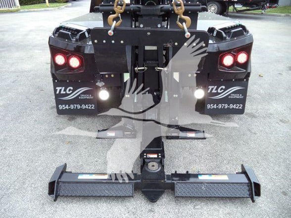 Tow truck rear view with hitch and hook attachments, Freightliner TLC branding on fenders, stock number JU6169FM.