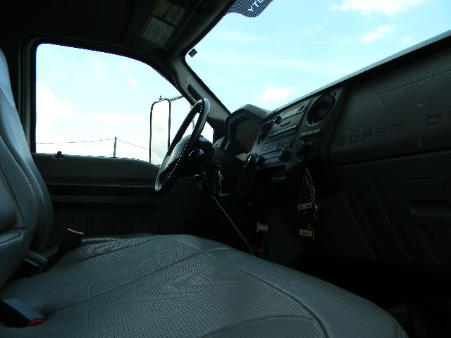Ford Super Duty dashboard and steering wheel inside service/utility truck cab with gray seats and black dashboard. Visible: steering wheel, instrument cluster, and center console.