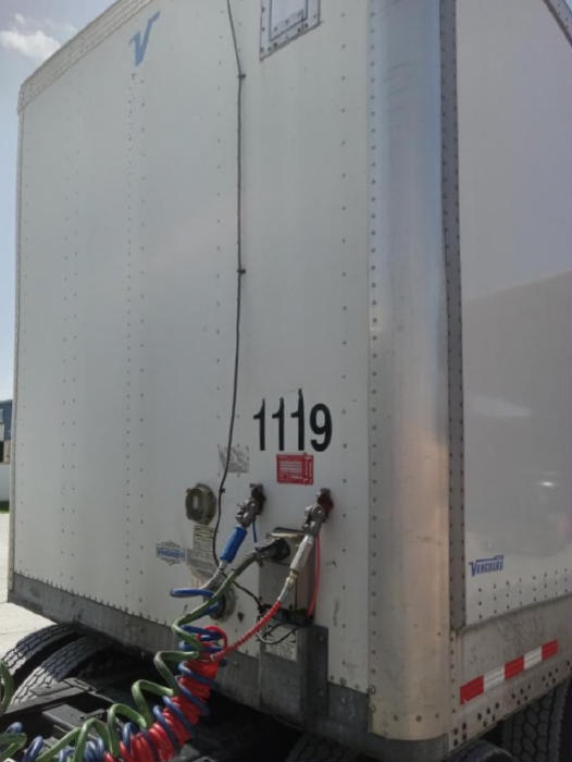 2018 Vanguard VXP trailer rear showing stock number 1119 and electrical hoses connected to trailer kingpin area.