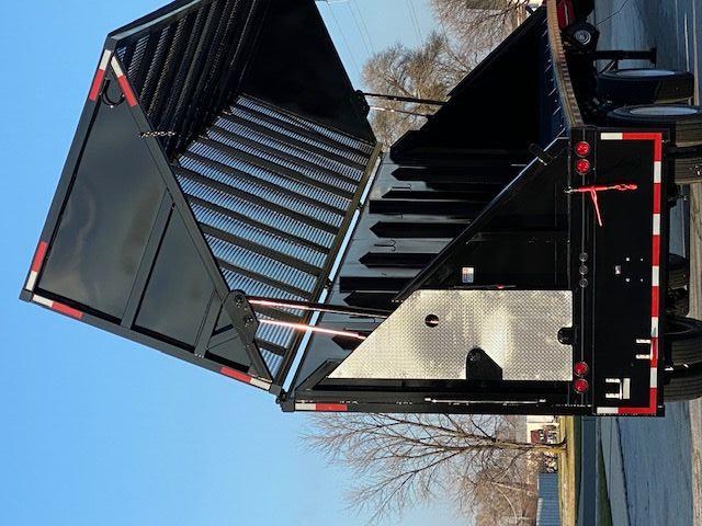 Crush car carrier trailer with tilting bed and black finish, rear view showing loading ramp and chains.
