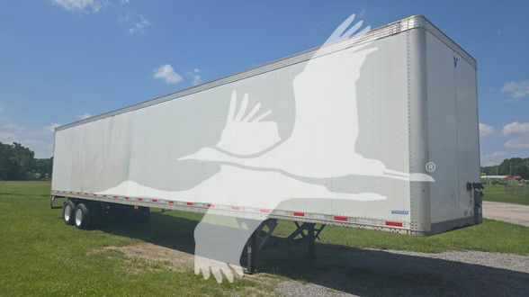 Vanguard trailer side view showing plain silver exterior and dual rear axle, no visible branding text.