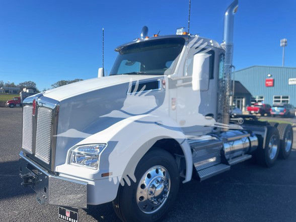 Kenworth T880 conventional daycab truck in white with chrome accents, showing side view of cab and front grille