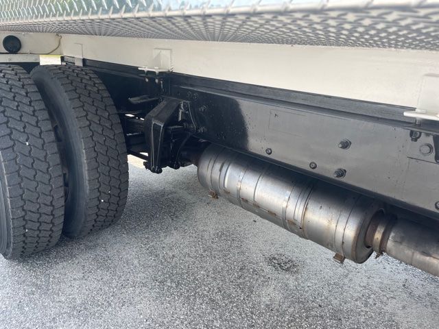 Freightliner M2 undercarriage showing dual rear tires, frame, and exhaust/muffler along side.