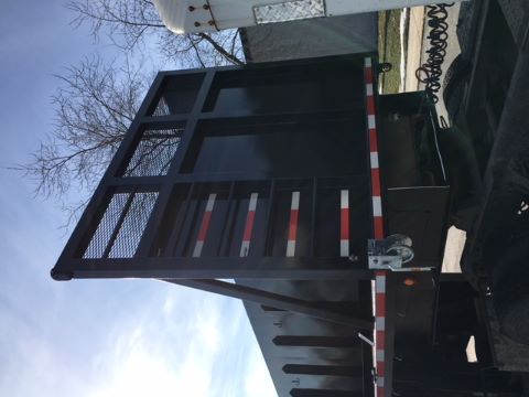 Great Dane single drop trailer rear view showing tall ramp and black steel body with reflective red/white stripes.