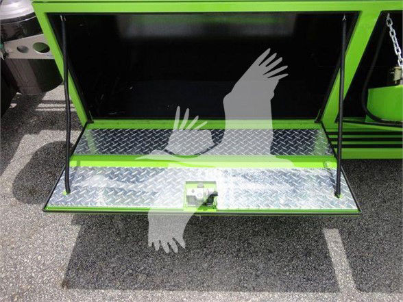 Truck side open storage compartment with diamond plate metal step and green-painted frame; a rear hatch/step with a latch is visible.