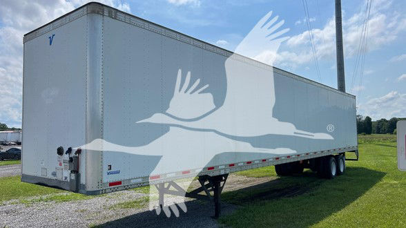 Trailer side view showing long rectangular cargo trailer with dual rear axles and landing gear, light gray with white eagle artwork.