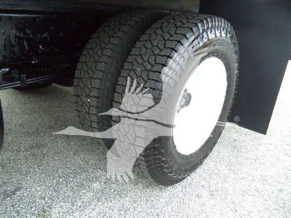 Isuzu NPR HD wheel and tire visible with white steel rim. Part of a box truck chassis. Text visible on the listing page: Stock Number: T11138FM, Category: Box, Type: Trucks, NewUsed: Used.