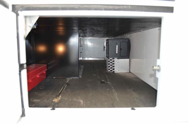 Kenworth T370 storage compartment showing empty cargo area with metal walls and a small vented unit on the right side.