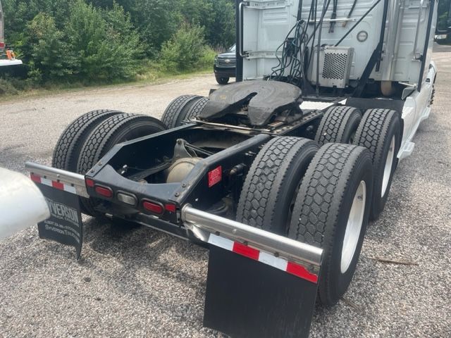 Volvo VNL64T740 sleeper cab tractor rear view showing dual rear axles, fifth wheel, mud flaps, and cab access area.