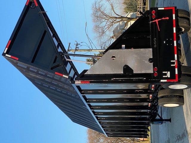 Transcraft 48 ft dump trailer with open-top body raised, black metal sides, dual rear axles, and reflective safety stripes.