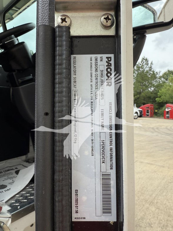 Kenworth L770 cab entry showing vehicle emission control information label with VIN and barcodes.