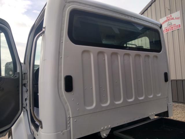 Freightliner M2 truck cab rear door and window side with vertical panels and entry door open.