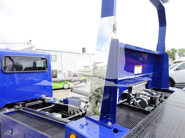 Blue Peterbilt 337 truck bed with hydraulic lift and metal stairs. Visible text on small orange label on inner panel.