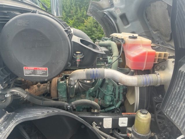 Volvo VNL64T740 engine bay showing coolant reservoir, hoses, and engine block with surrounding components.