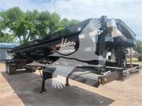 Trailer/attachment with hydraulic arm and black paint; visible branding on side, showing 'U.S.','310' or similar digits; no legible model or serial numbers clearly readable.