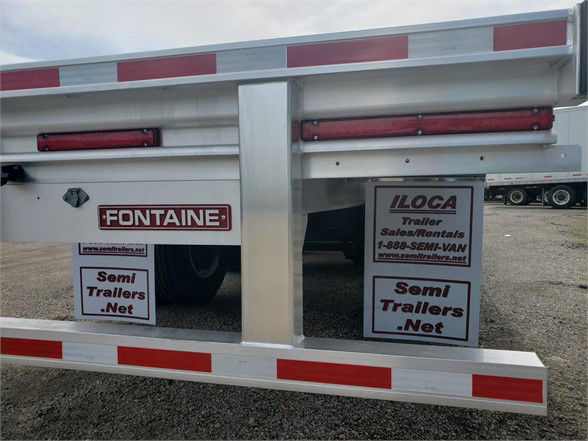Rear view of a Fontaine Revolution 52 all-aluminum 53ft tri-axle flatbed trailer with red clearance lights and Fontaine logo plate, ILoca trailer signs, and semi-trailer.net banners.