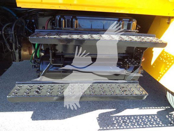 Truck access area showing steps and engine bay components of a 2019 International Durastar 4300, with metal steps and hydraulic lines visible.