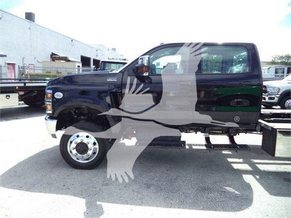 Front-left side view of a black 2023 International CV tow truck with a dual rear wheel, showing side mirrors and cab details.