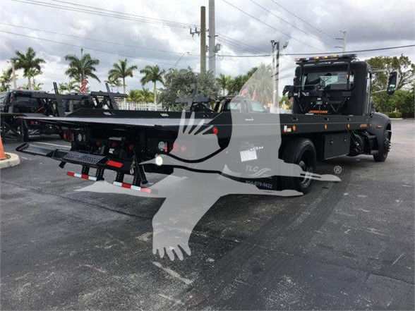Peterbilt 337 tow truck with a lowboy trailer on a lot. Visible text includes stock number J99287 and watermarked logo on the image.