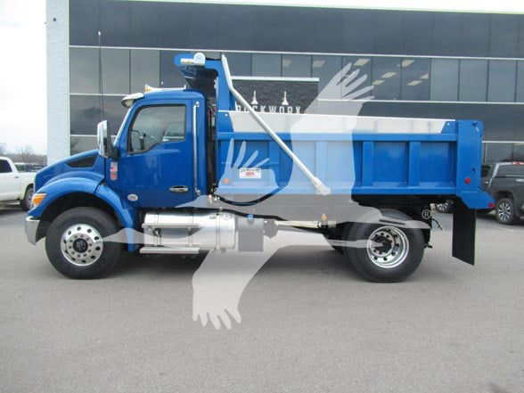 Kenworth T380 dump truck in blue with silver fuel tank and black rear bed, side view showing cab, front wheel, and hydraulic dump mechanism.
