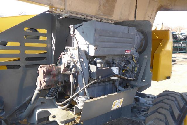 Tractor crane boom truck engine bay showing diesel engine and hydraulic pump assembly.