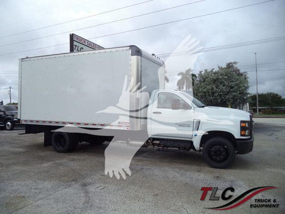 Box truck in a parking lot showing a white Chevrolet Silverado 6500HD with a large box cargo area. TLC Truck & Equipment watermark.