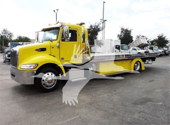 Yellow Peterbilt 337 tow truck with flatbed in dealership lot. Visible text includes stock number J56560 and category/tow truck information in the listing context