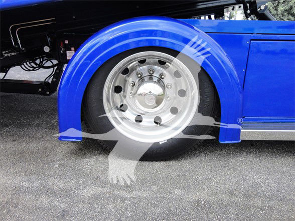 Truck wheel well with blue fender and steel wheel showing hub and lug nuts.