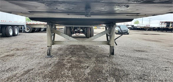 Underneath view of a Vanguard dry van trailer showing the undercarriage and support frame on a gravel lot.