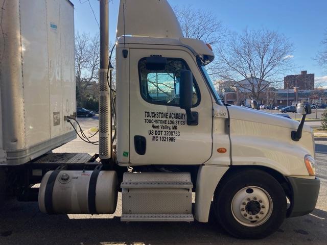 Truck cab shows text on door: TOUCHSTONE ACADEMY TOUCHSTONE LOGISTICS Hunt Valley, MD US DOT 3280753 MC 10219989. Side of sleeper shows numbers 4?5?   Front wheel, exhaust stack visible.