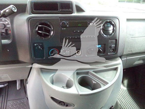 Ford E-Series van dashboard and center console showing infotainment and control knobs.