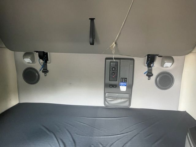 Truck cab sleeper area showing rear wall with integrated controls, two speakers, and a central panel.