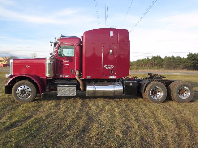 Peterbilt 388 conventional sleeper truck side view with maroon cab, chrome fuel tanks, and dual rear axles.