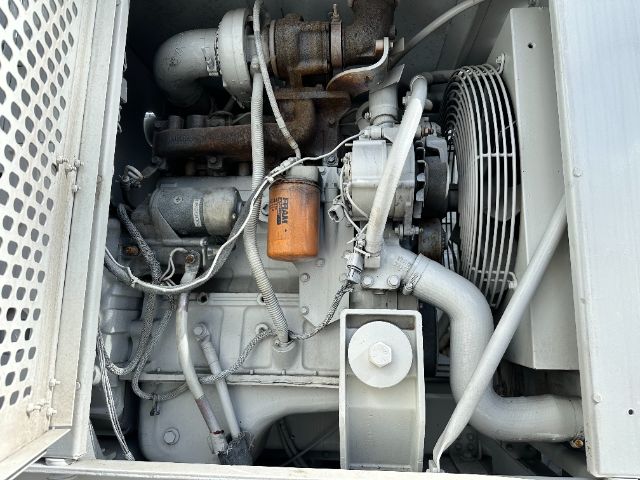 Engine bay of a 2000 International F-2554 showing radiator fan, orange oil filter, hoses, and turbo components.