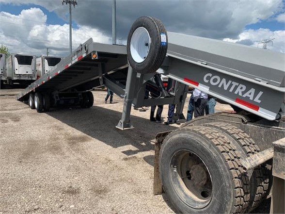 Trailer showing a tanDEM axle drop deck container delivery trailer with CONTRAL branding, wheel, and suspension components visible.