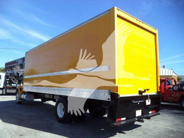 Back/side view of a yellow box truck with a closed cargo area and white wheels. The right rear is visible. No readable labels on the side.