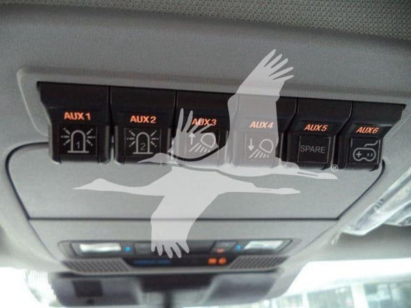 Ford F-450 overhead console showing multiple auxiliary switches labeled AUX 1 to AUX 6, with icons for electrical/battery connections and a spare switch.