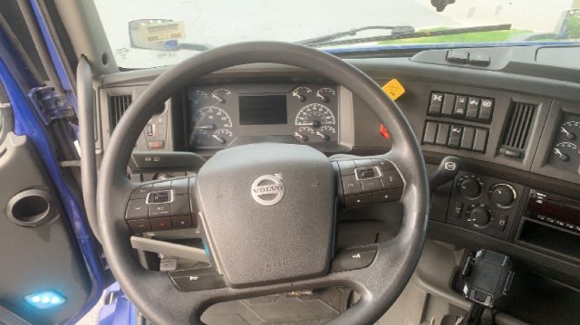 Volvo truck interior steering wheel and dashboard with gauges and controls.