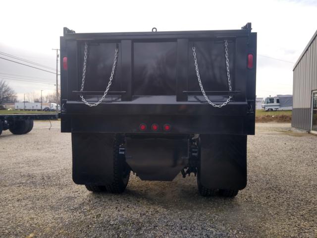 Rear view of a black Freightliner M2 dump truck body with chain gates and taillights.