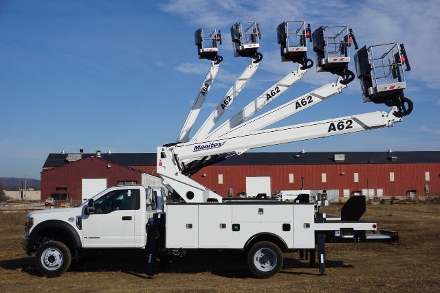 Ford F-550 bucket truck with Manitex A62 articulating boom lift deployed in air, four telescoping sections labeled A62, utility body with side compartments, white cab and chassis.