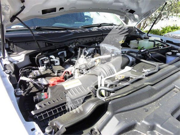 Ford F-550 engine bay showing multiple components, air intake, battery, hoses, and fluid reservoirs in view.